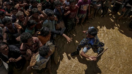A security officer attempts to control Rohingya refugees waiting to receive aid in Cox's Bazar, Bangladesh © Cathal McNaughton 