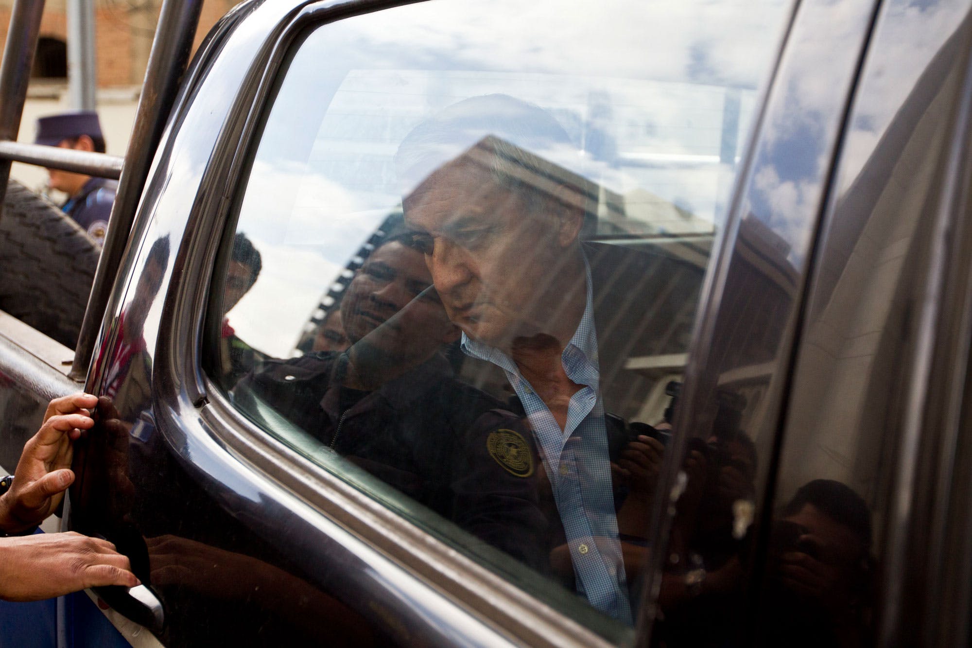 Guatemalan former President Otto Perez Molina arrives in a police vehicle to a court hearing in Guatemala City, Monday, June 13, 2016. The ex-president faces charges of money laundering and conspiracy. Three senior Guatemalan cabinet, all who served under Perez Molina, were arrested Saturday on corruption charges, and authorities said they were seeking to detain two more as part of a continuing crackdown that has seen the former president and his vice president jailed. (AP Photo/Moises Castillo)