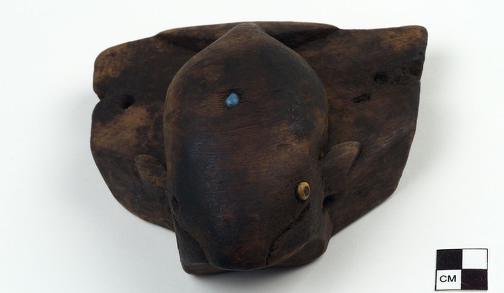 Another Umiak seat representing a whale, made of wood and inlaid with glass beads.