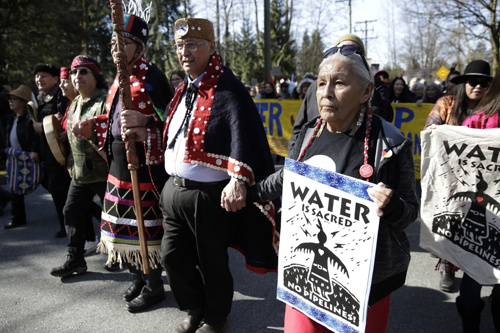 Harriet Prince (R), 76, of the Anishinaabe tribe marches with Coast Salish Water Protectors and others against the expansion of Texas-based Kinder Morgan's Trans Mountain pipeline project in Burnaby, British Columbia, Canada on March 10, 2018.  / AFP PHOTO / Jason Redmond        (Photo credit should read JASON REDMOND/AFP/Getty Images)