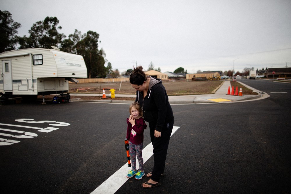 Michelle's Teixeira comforts her 4 year old daughter who had been playing with other kids who are living in trailers on undeveloped lots after their homes were burned by the Camp Fire, Chico, California, December 21st, 2018. Michelle Teixeira is living in a 300 square foot trailer with her husband, her father, two daughters, and four dogs. Her husband’s boss owns a residential development made up of 36 empty lots, where the Teixeiras and five other families have made camp, calling themselves the “trailer treasures.” They’re all refugees from the Camp wildfire, which leveled Paradise, California, killing 86 people, including many retirees.Talia Herman for The Intercept