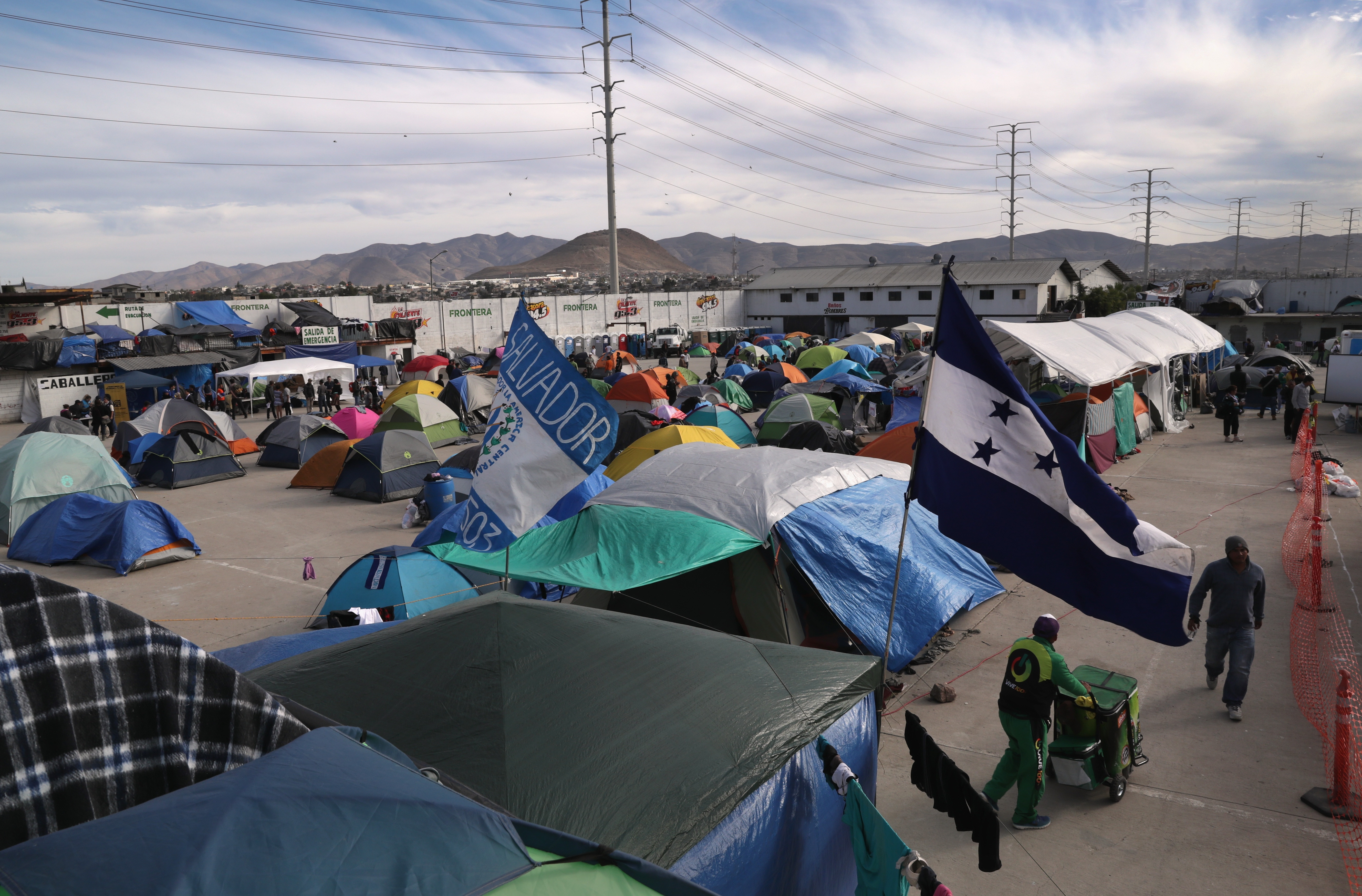 TIJUANA, MEXICO - DECEMBER 04:  Honduran and Salvadorian flags fly over the Barretal migrant caravan camp on December 4, 2018 from Tijuana, Mexico. After traveling more than 6 weeks from Central America, thousands of immigrants remain in Tijuana, many awaiting asylum interviews and others deciding whether to cross illegally into the United States. (Photo by John Moore/Getty Images)