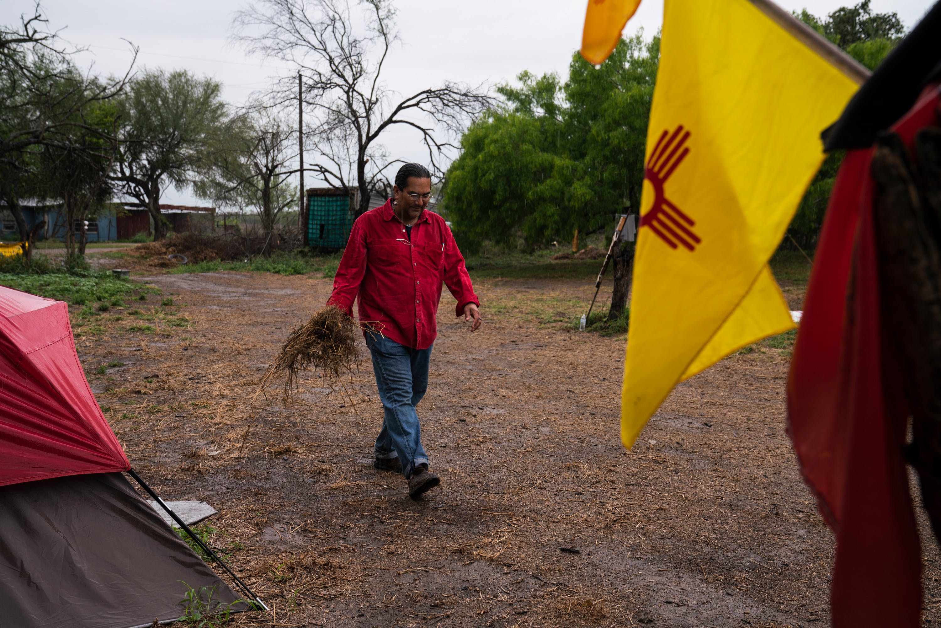 Christopher Basaldú, PhD in anthropology, collects grass to place it outside of his tent to clean up the mud from his shoes at Yalui Village in Hidalgo County, Texas on March 19, 2019. Basaldú has been camping for two months in anticipation of the border wall being built. Photo: Verónica G. Cárdenas for The Intercept