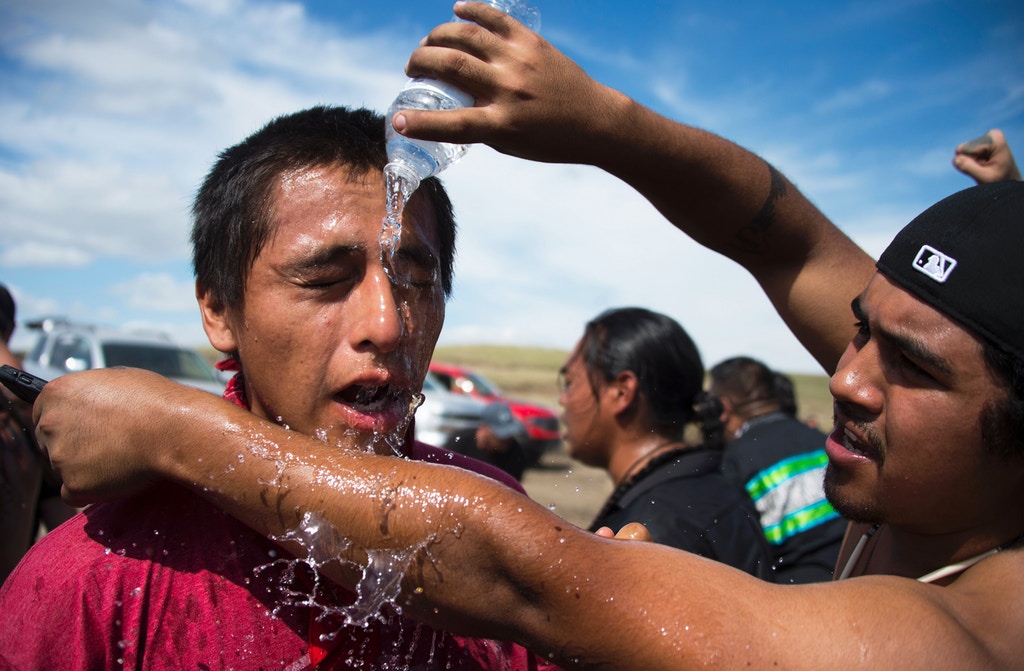 A protestor is treated after being pepper sprayed by private security contractors on land being graded for the Dakota Access Pipeline (DAPL) oil pipeline, near Cannon Ball, North Dakota, September 3, 2016.  Hundreds of Native American protestors and their supporters, who fear the Dakota Access Pipeline will polluted their water, forced construction workers and security forces to retreat and work to stop. / AFP / Robyn BECK        (Photo credit should read ROBYN BECK/AFP/Getty Images)