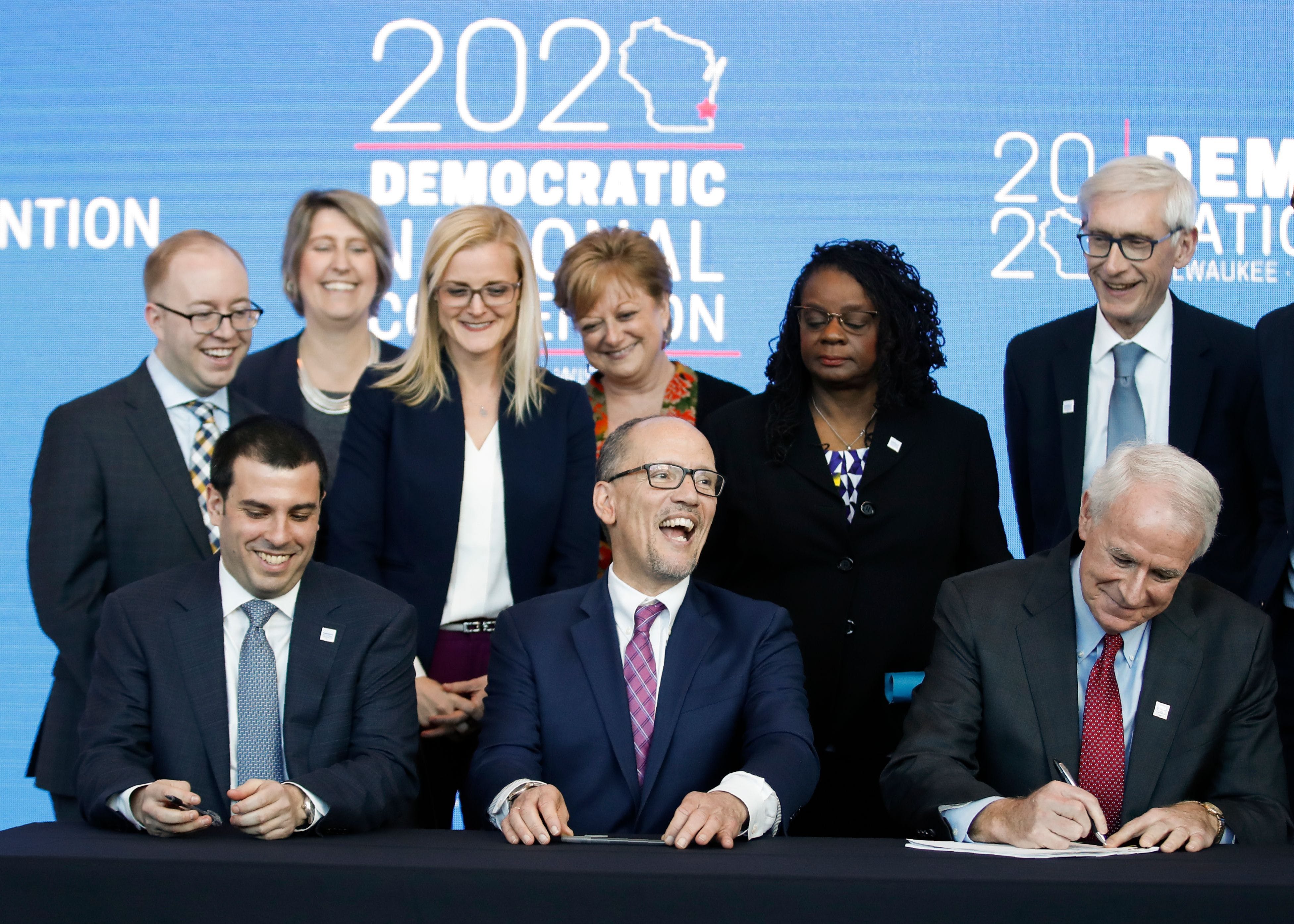 Milwaukee Mayor Tom Barrett (bottom R) signs a document announcing the selection of Milwaukee as the 2020 Democratic National Convention host city as Wisconsin Governor Tony Evers (R) and Chair of the Democratic National Committee Tom Perez (bottom C) look on during a press conference at the Fiserv Forum in Milwaukee, Wisconsin on March 11, 2019. - Democrats have chosen Milwaukee as the site of their 2020 election convention, in an effort to win back swing voters in the American "Rust Belt" who helped elect Donald Trump. In announcing the decision, the Democratic Party emphasized it is the first time a Midwestern city other than Chicago has been chosen to host a party convention in more than 100 years. (Photo by Kamil Krzaczynski / AFP)        (Photo credit should read KAMIL KRZACZYNSKI/AFP/Getty Images)