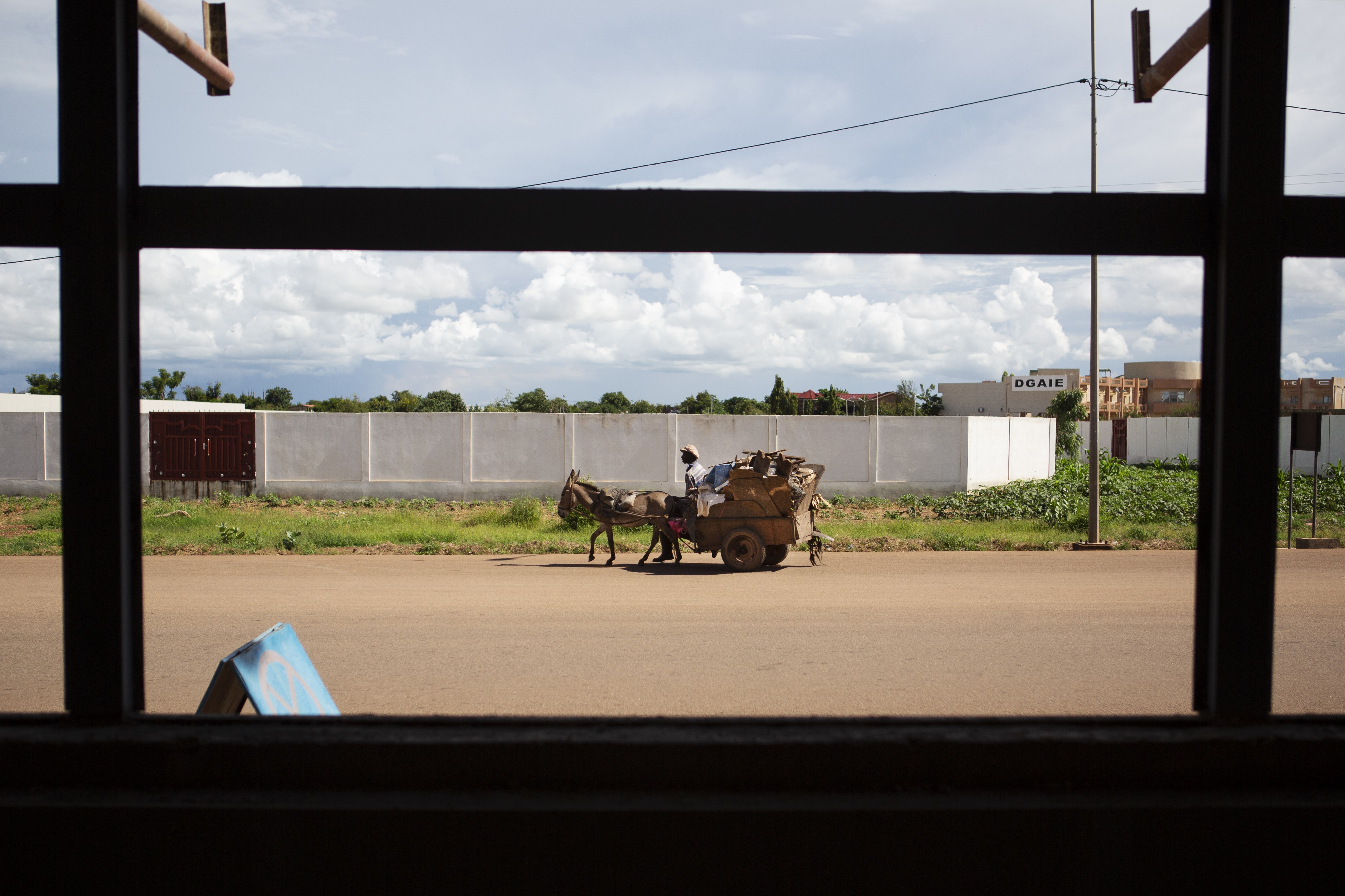 A garbage collected rids his donkey-led carriage on a street closed for the trial against former General Gilbert Diend?r? and the coup plotters of 2015 in the Ouaga 2000 neighborhood of Ouagadougou, Burkina Faso, August 28, 2018. Joe Penney for The Intercept